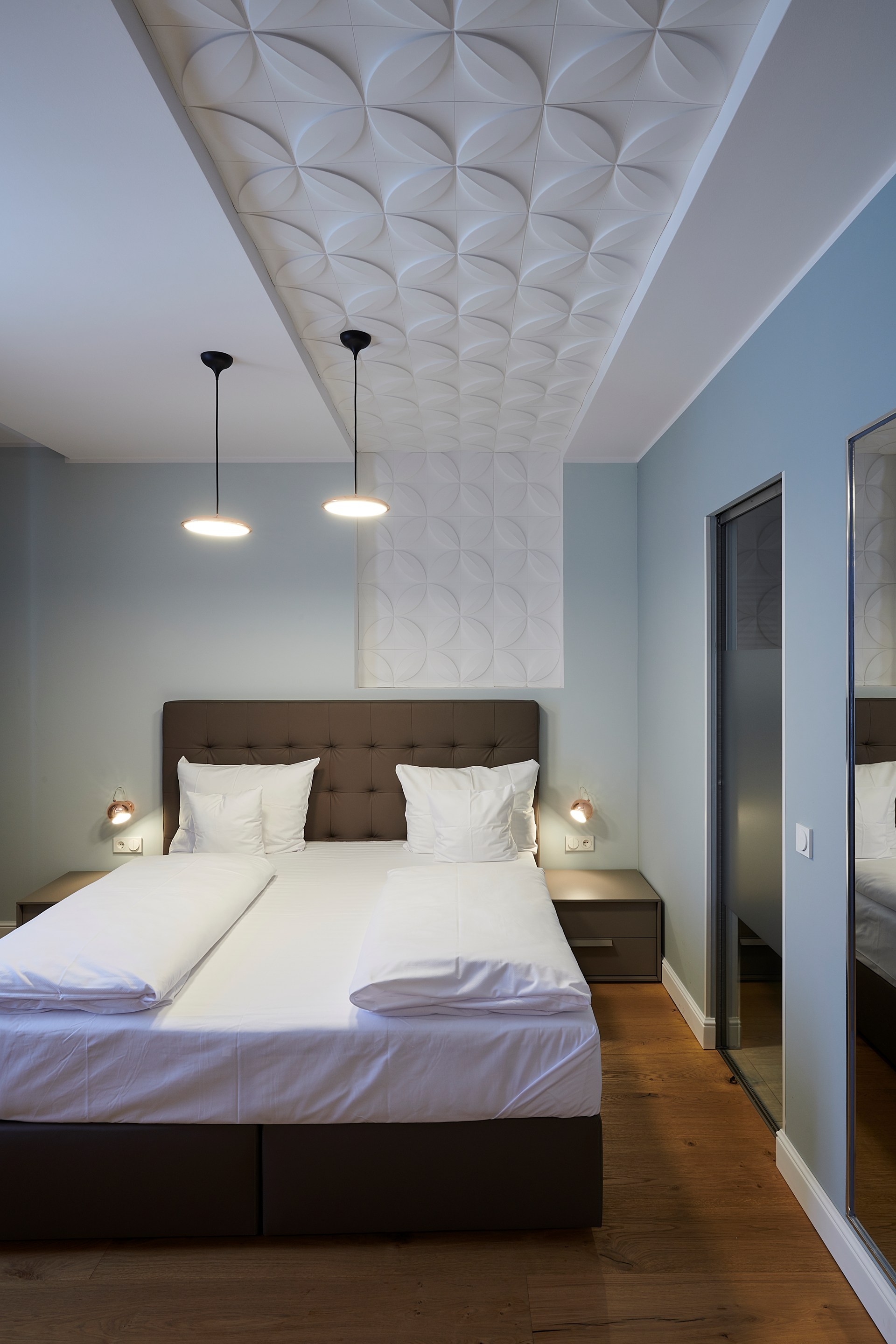Decorative wall panels applied to the ceiling, creating a textured ceiling feature above the bed.